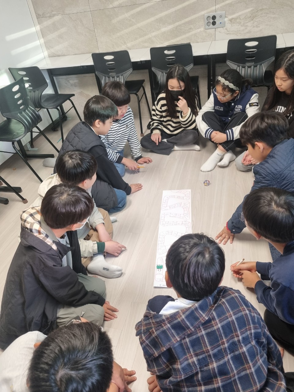 울산 센트리지 영어 프라임 영어 문법 게임 수업, 학생들이 둘러앉아 주사위 보드게임 하는 모습